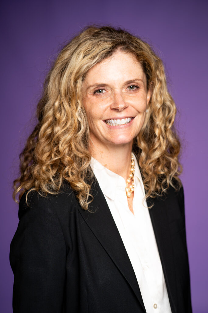 Shanna Gowen - A woman in professional attire in front of a purple background
