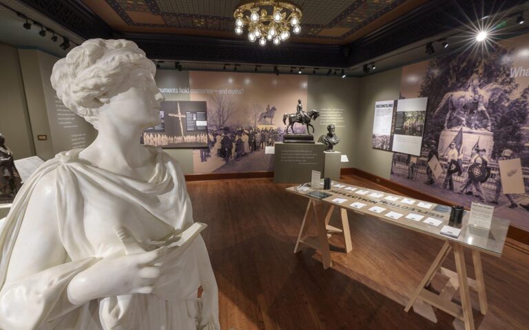 Marble statue in the foreground of an exhibit display