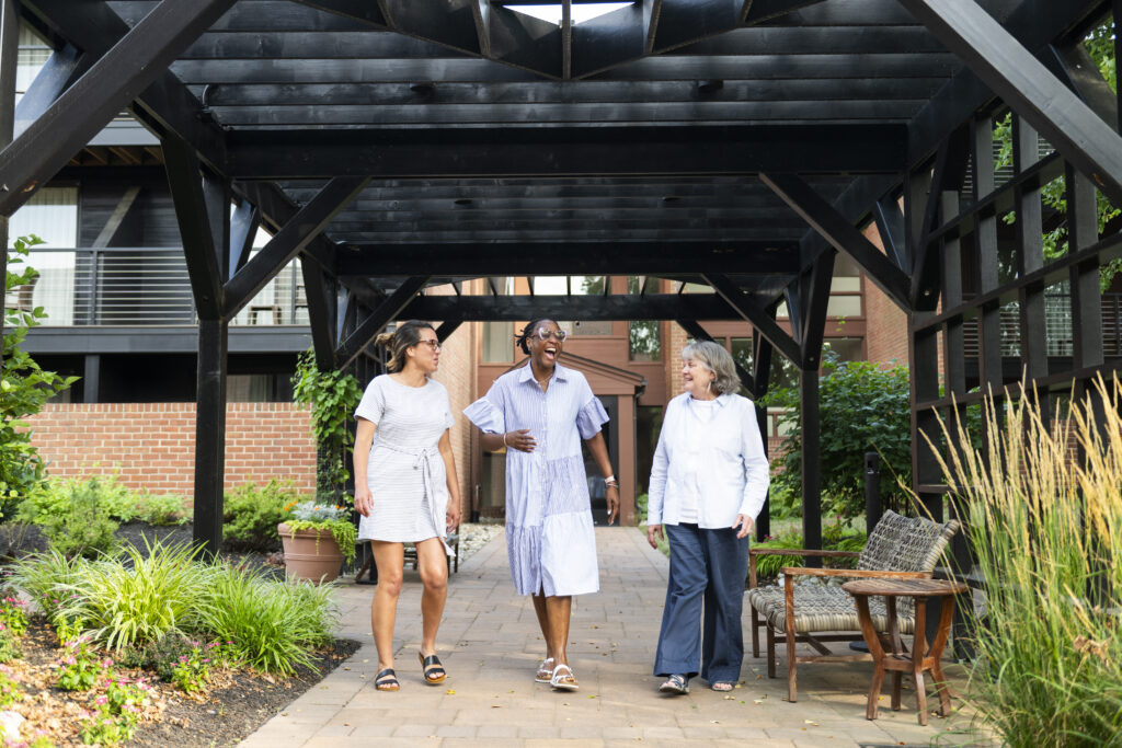 Three women walking outside laughing together